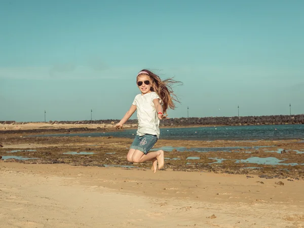 Mała dziewczynka skok na plaży — Zdjęcie stockowe