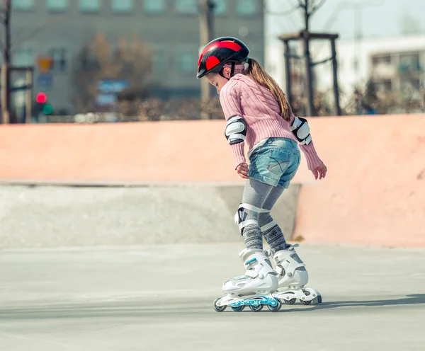 Pequena menina bonita em patins — Fotografia de Stock