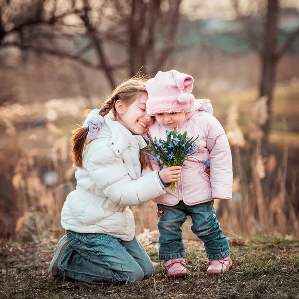 Holčička a sestra drží kytici — Stock fotografie