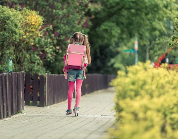 Meisje gaat naar school op scooter — Stockfoto