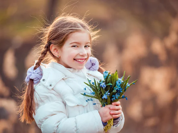 Kleines Mädchen mit Schneeglöckchen — Stockfoto