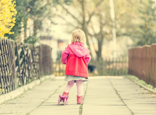 Year-old girl riding her scooter — Stock Photo, Image