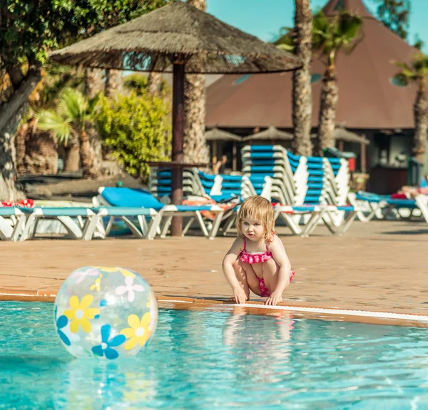 Niña sentada cerca de la piscina — Foto de Stock