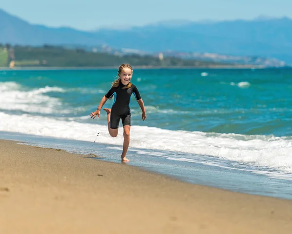 Menina correndo ao longo da praia — Fotografia de Stock
