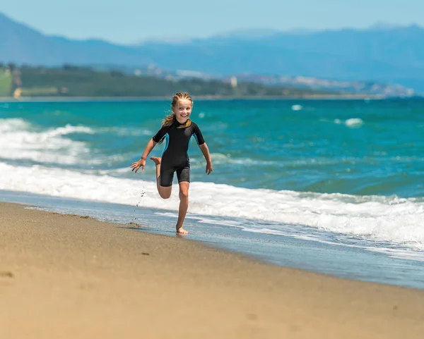 Mädchen läuft am Strand entlang — Stockfoto