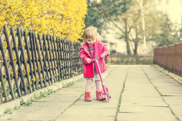 Маленька дівчинка їде на скутері — стокове фото