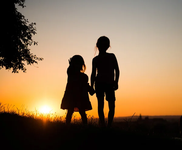 Silhouette de deux jeunes sœurs — Photo