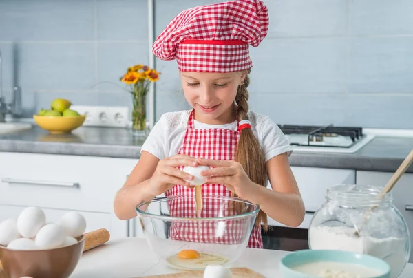 Niña rompiendo huevos en un tazón — Foto de Stock