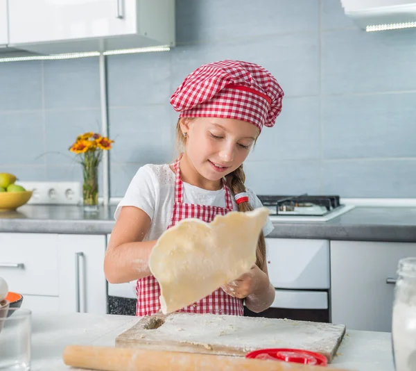 Kleines Mädchen rollt Teig aus — Stockfoto