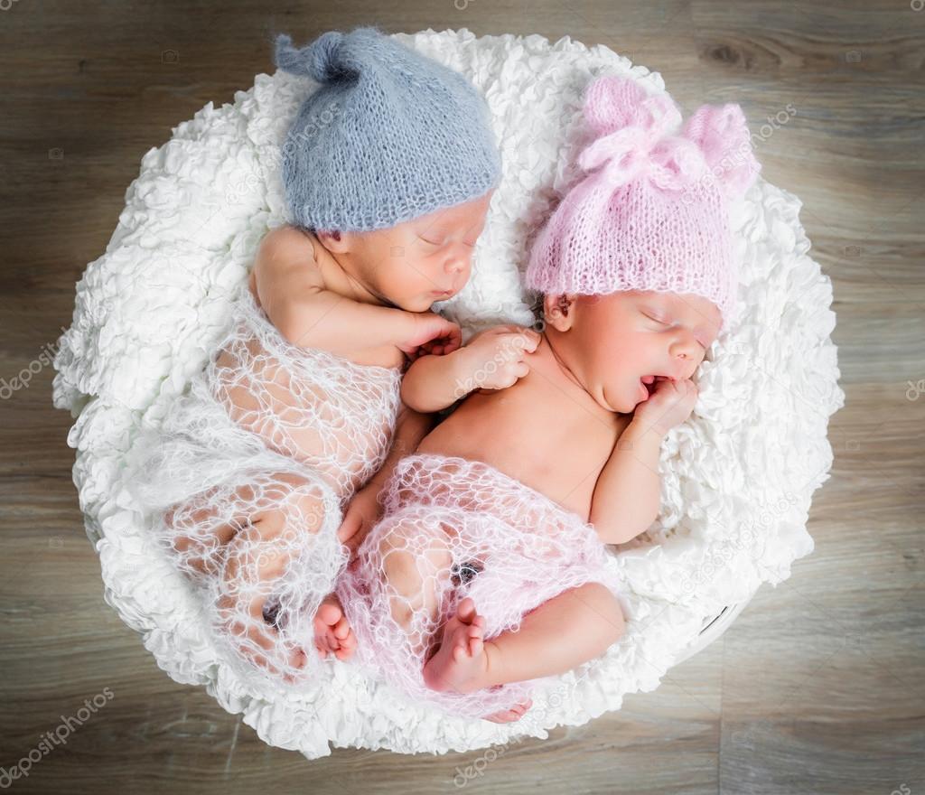 Gemelos recién nacidos l durmiendo en una cesta: fotografía de