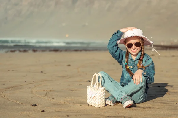 Little girl in a hat on the  beach — Stock Photo, Image