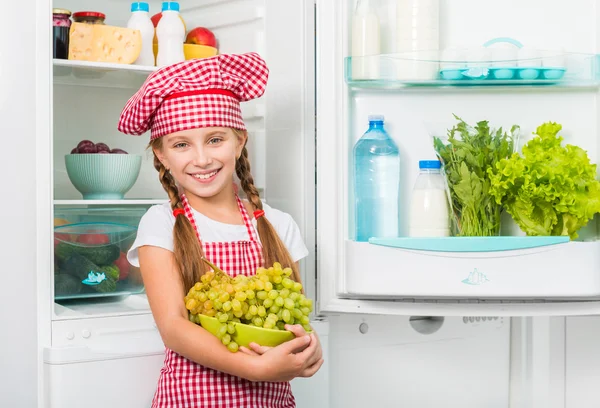 Menina cozinheiro segurando uvas — Fotografia de Stock