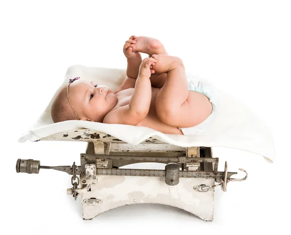 レトロな体重計の上に横たわる小さな赤ちゃん — ストック写真