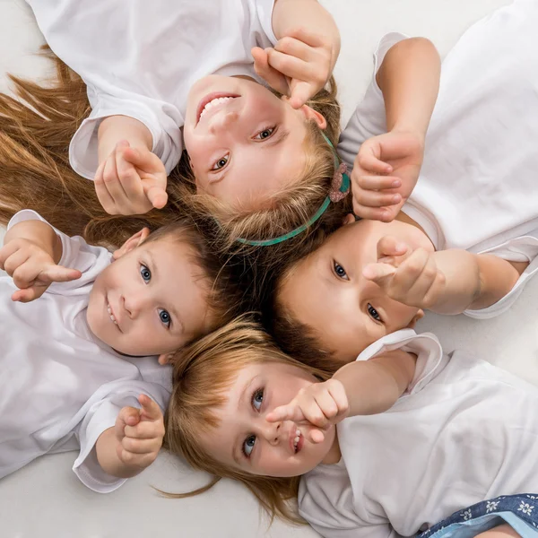 Niños sonrientes acostados juntos — Foto de Stock