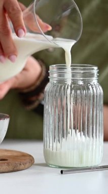 Kadın, Matcha Latte yapmak için kavanoza süt döker.