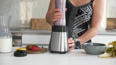 Muz, çilek ve yabanmersiniyle Kokteyl Yapan Kadın