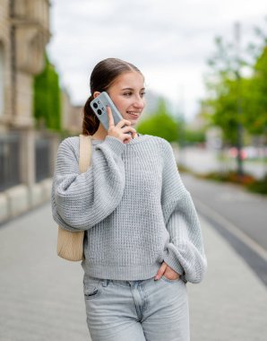 Şehir caddesinde telefonda konuşan tatlı kız.