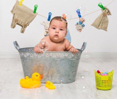 baby girl bathes in   trough clipart