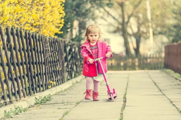 Meisje haar scooter rijden — Stockfoto