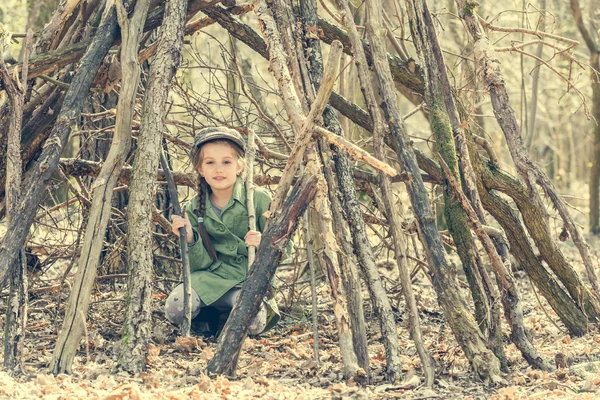 Klein meisje in het bos in de buurt van hut — Stockfoto