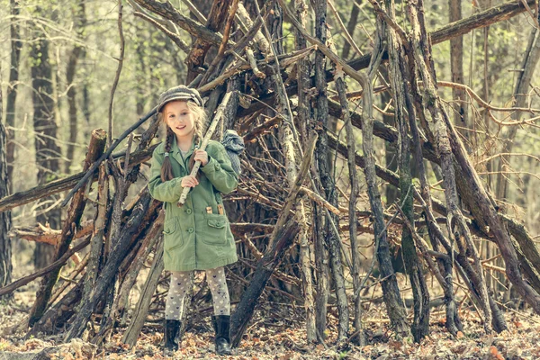Маленькая девочка возле хижины в лесу — стоковое фото
