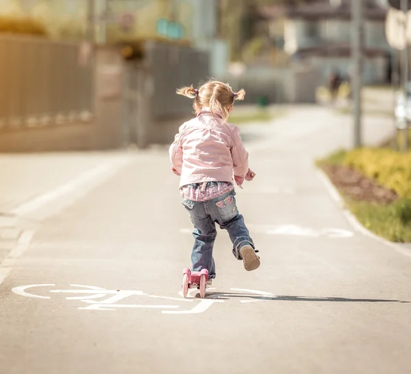 Liten flicka Rider hennes scooter — Stockfoto