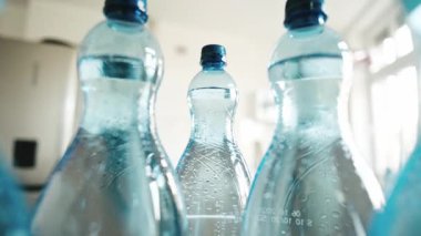 Kızlar büyük bir şişe köpüklü su alır ve kamera şişelerin arasında düzgün bir şekilde hareket eder.