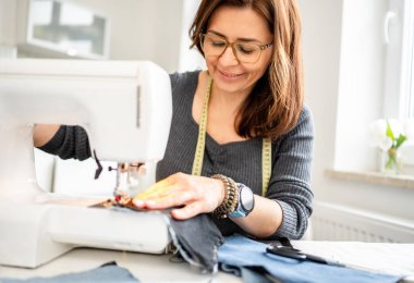 Dikiş makinesinde dikiş diken kadın