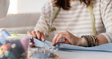 Woman Folding Fabric Edge And Sewing At Home