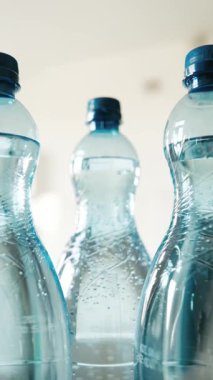 Kızlar büyük bir şişe köpüklü su alır ve kamera şişeler arasında düzgünce hareket eder.