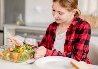 Mutfakta salatasını servis eden mutlu kız.