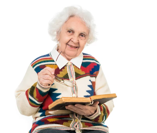 Mulher idosa lançando um livro velho — Fotografia de Stock