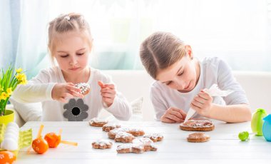 Paskalya için zencefilli kurabiye süsleyen iki küçük kız