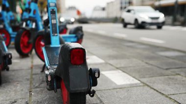 Geçen arabalarla Bulanık Arkaplanda Duran Elektrikli Scooterlar
