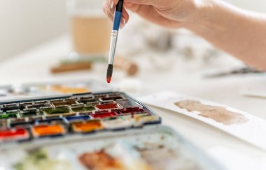 Suluboya resmine fırça batıran bir kadının yakın çekimi