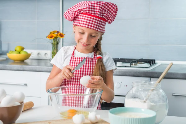 Niña rompiendo huevos en un tazón — Foto de Stock