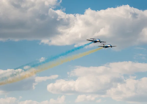 Літаків в небо з барвистими дим український прапор — стокове фото