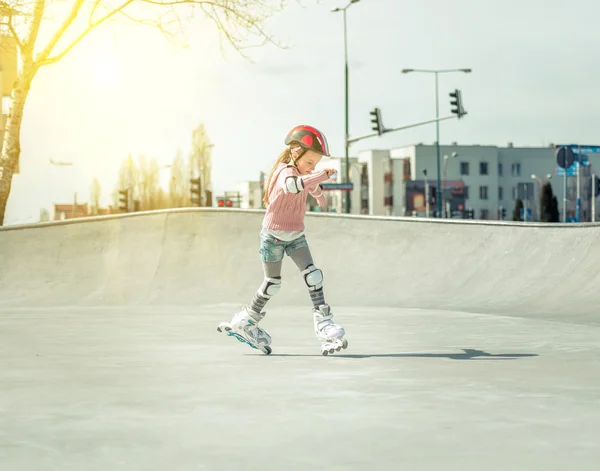 Pequena menina bonita em patins — Fotografia de Stock