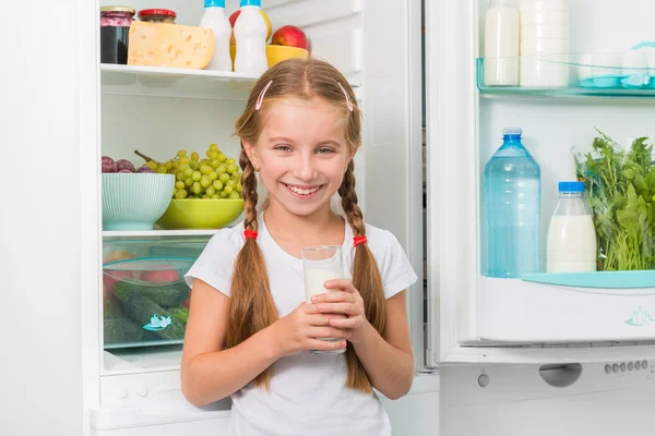 Liten flicka som håller ett glas mjölk — Stockfoto