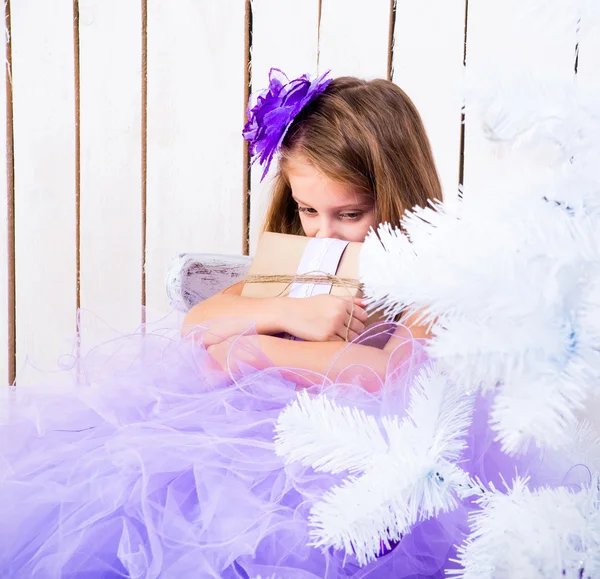 Sad little girl with a gift — Stock Photo, Image