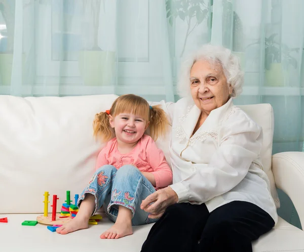 Κοριτσάκι με γιαγιά σε ένα καναπέ — Φωτογραφία Αρχείου