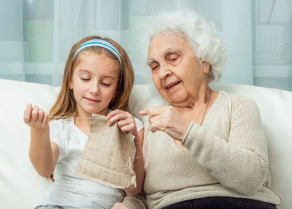 Ganddaughter aprender a bordar com vovó — Fotografia de Stock