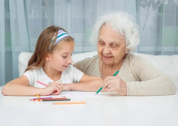 Menina e sua avó desenho com lápis — Fotografia de Stock