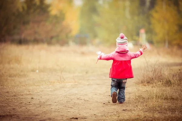 Little girl walking with windmill — Stock Photo, Image