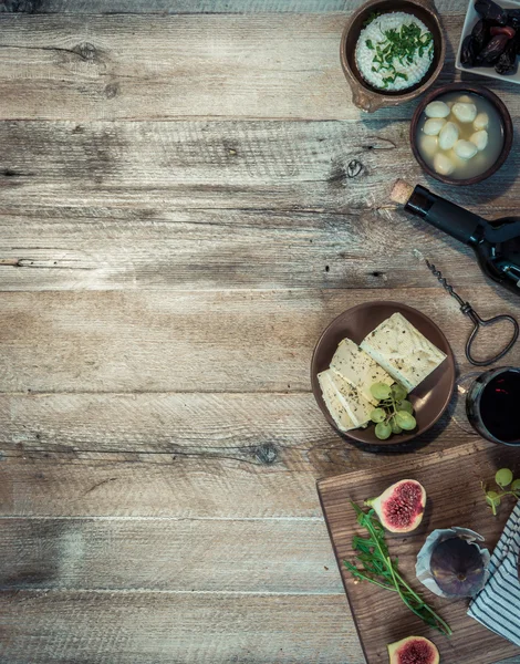 Quesos y pan moreno sobre mesa de madera — Foto de Stock