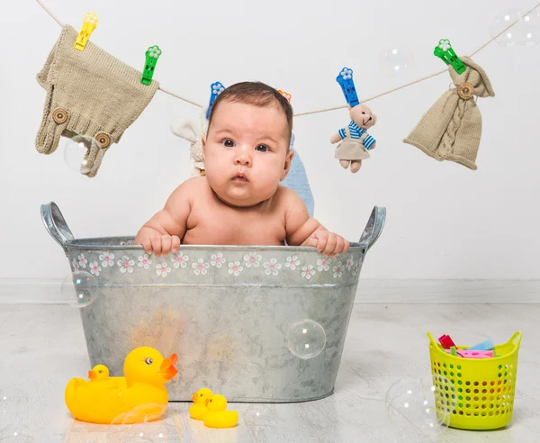 Bebê menina banhos em uma calha — Fotografia de Stock