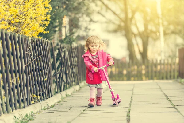 2 year-old girl riding her scooter — Stock Photo, Image