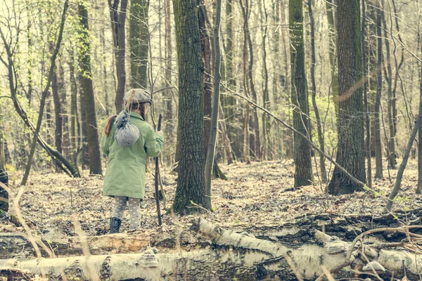 Маленькая девочка идет через лес — стоковое фото