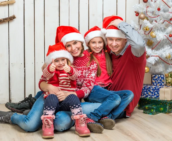 Grande famiglia a cappelli di Babbo Natale vicino all'albero di Natale — Foto Stock