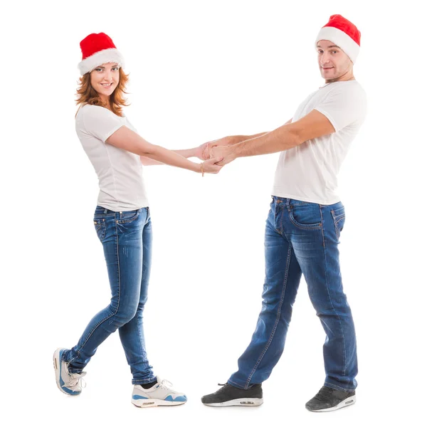 Jovem casal de mãos dadas em chapéus vermelhos — Fotografia de Stock